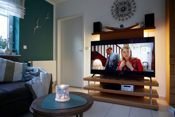 Moderner Smart TV mit DVD-Player und Stereoanlage.